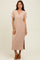 woman wearing a short sleeve beige ribbed maxi dress with a v-neck and side slit