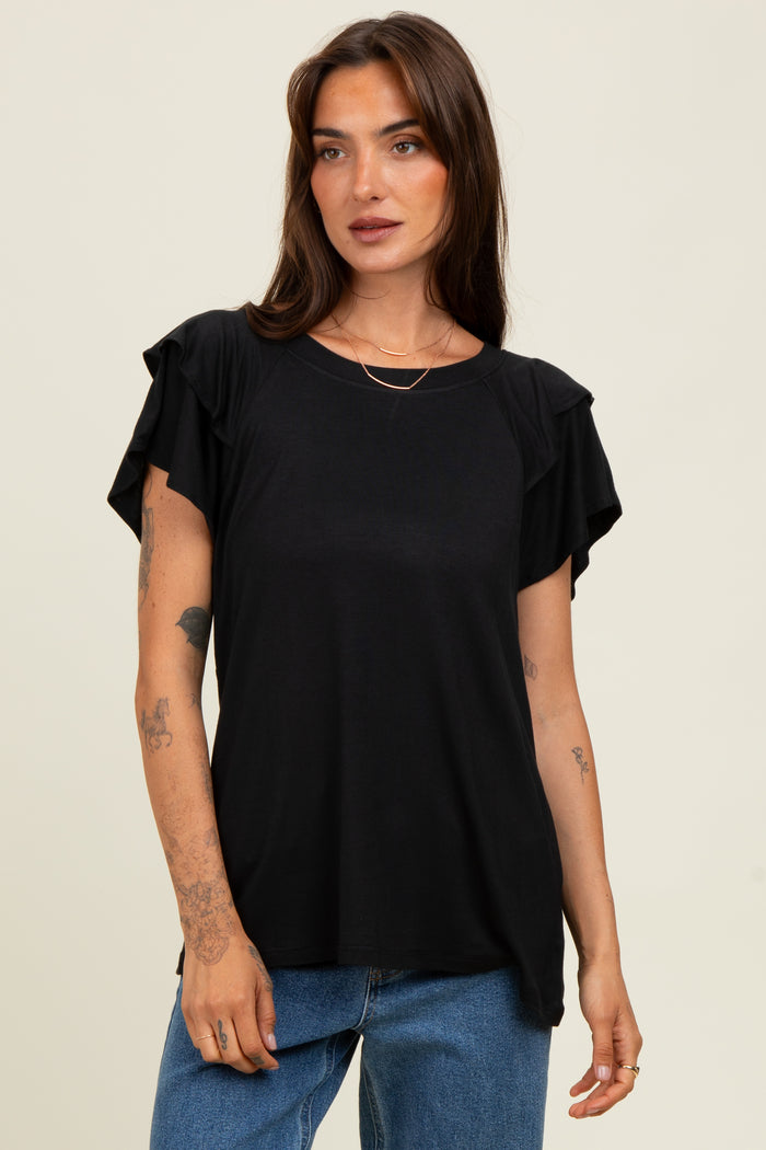 woman wearing a black short sleeve top with ruffled sleeves and a relaxed fit