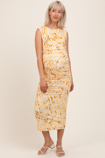 woman wearing a yellow and white patterned maternity midi dress with ruching and a visible baby bump