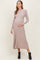 woman wearing a taupe ribbed long sleeve maternity dress and holding her baby bump