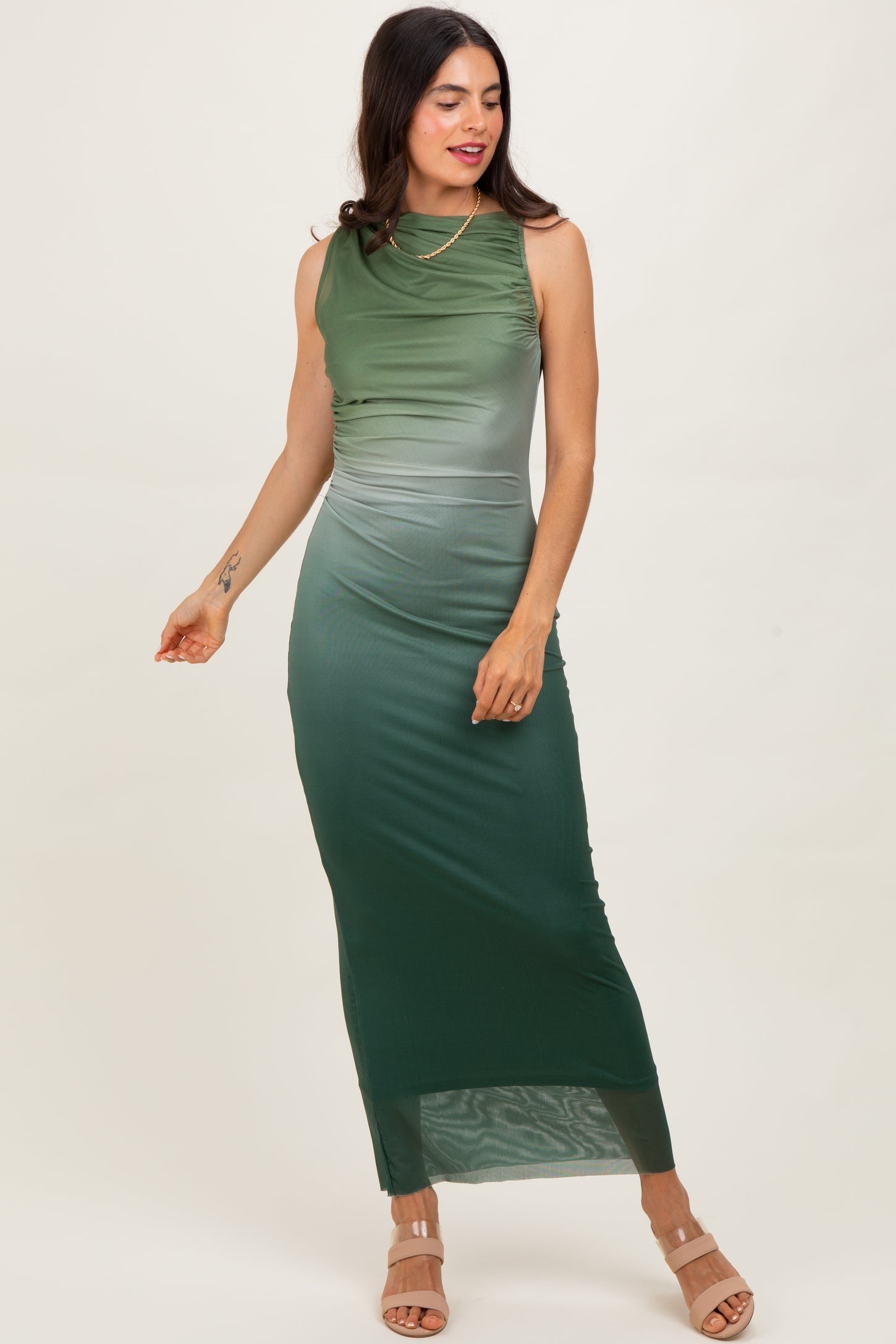 woman wearing a sleeveless green ombre maxi dress with a cowl neckline and side slit