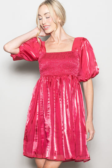 woman wearing a pink smocked balloon sleeve dress with a square neckline and a flared skirt