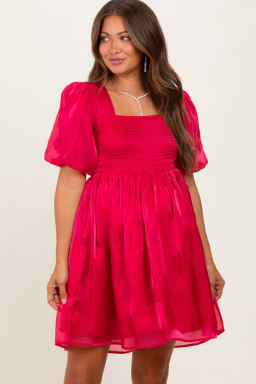 woman wearing a bright pink puff sleeve maternity dress with a smocked bodice and flowy skirt