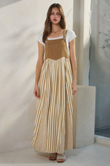 woman wearing a long striped tan and white maxi dress with buttons and a fitted top over a short sleeve white tee