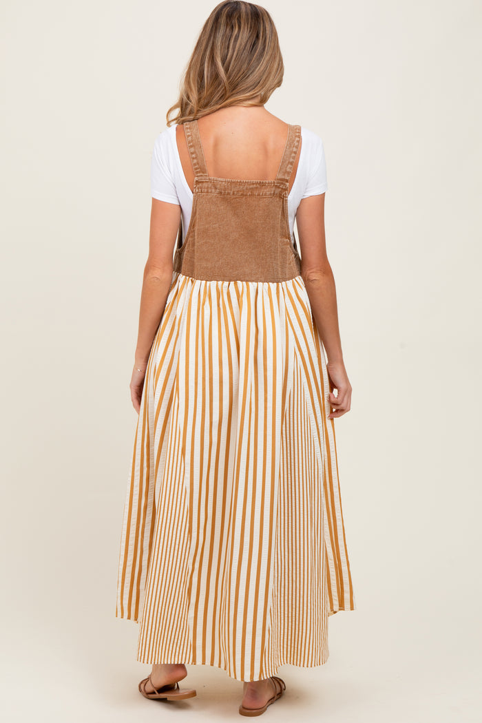 woman wearing a brown corduroy maternity maxi dress with white and mustard stripes and a fitted bodice