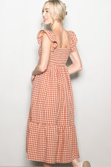 woman wearing a red and white gingham midi dress with ruffle sleeves and tiered skirt, seen from the back