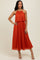 woman wearing an orange pleated midi dress with a halter neckline and layered bodice