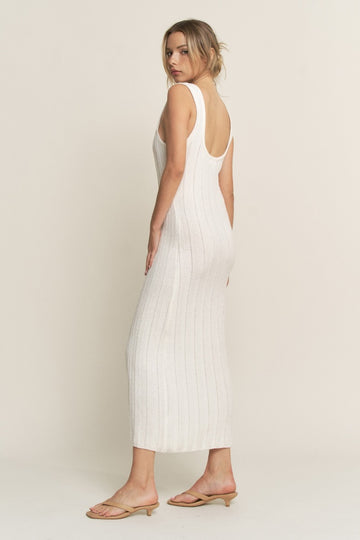 woman wearing a white ribbed knit sleeveless midi dress with a scoop back, paired with beige slide sandals
