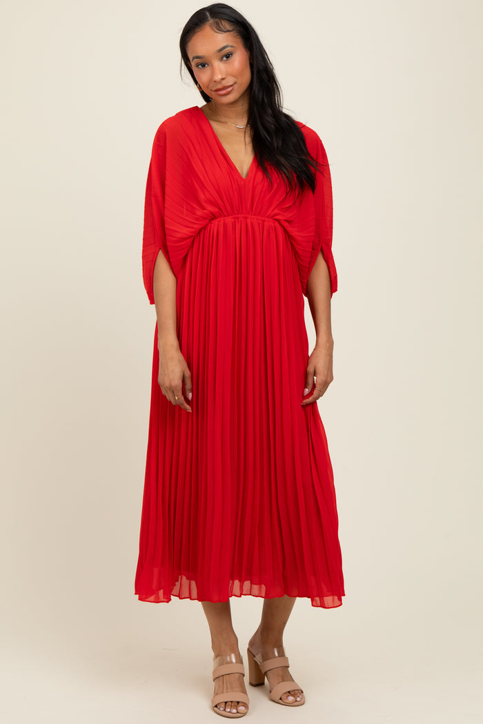 woman wearing a red pleated maxi dress with a deep v-neck and kimono sleeves