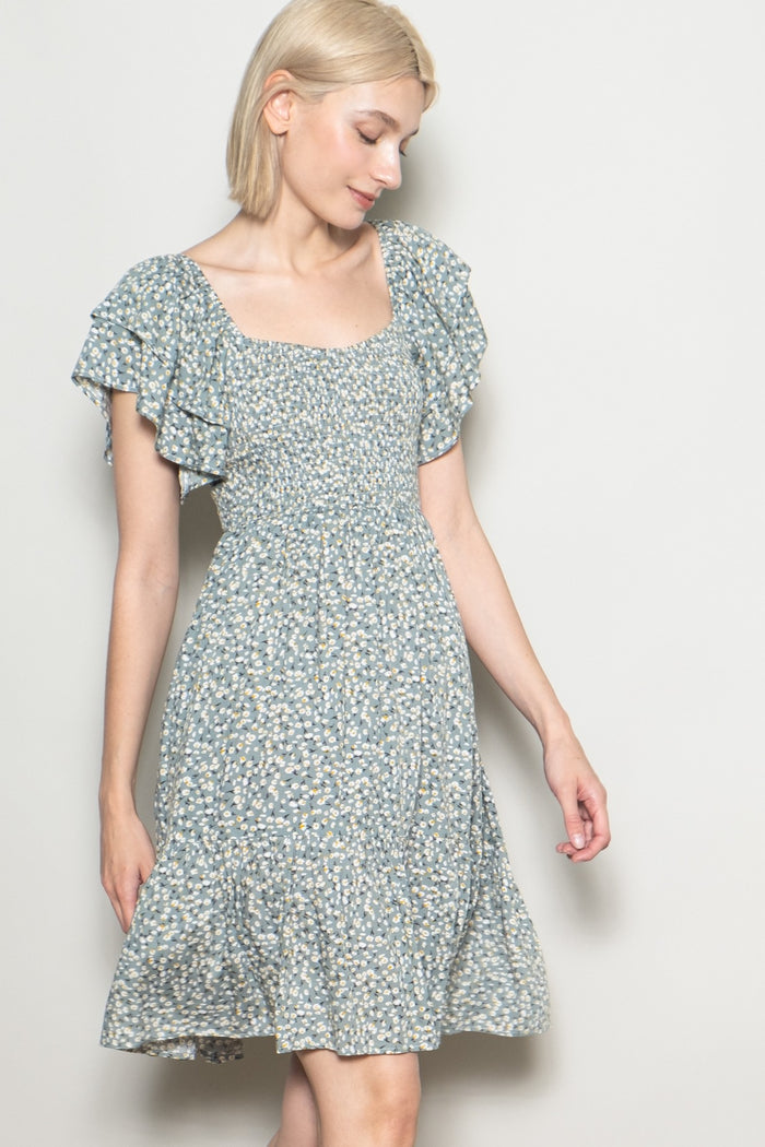 woman wearing a light blue floral short dress with ruffled sleeves and a square neckline