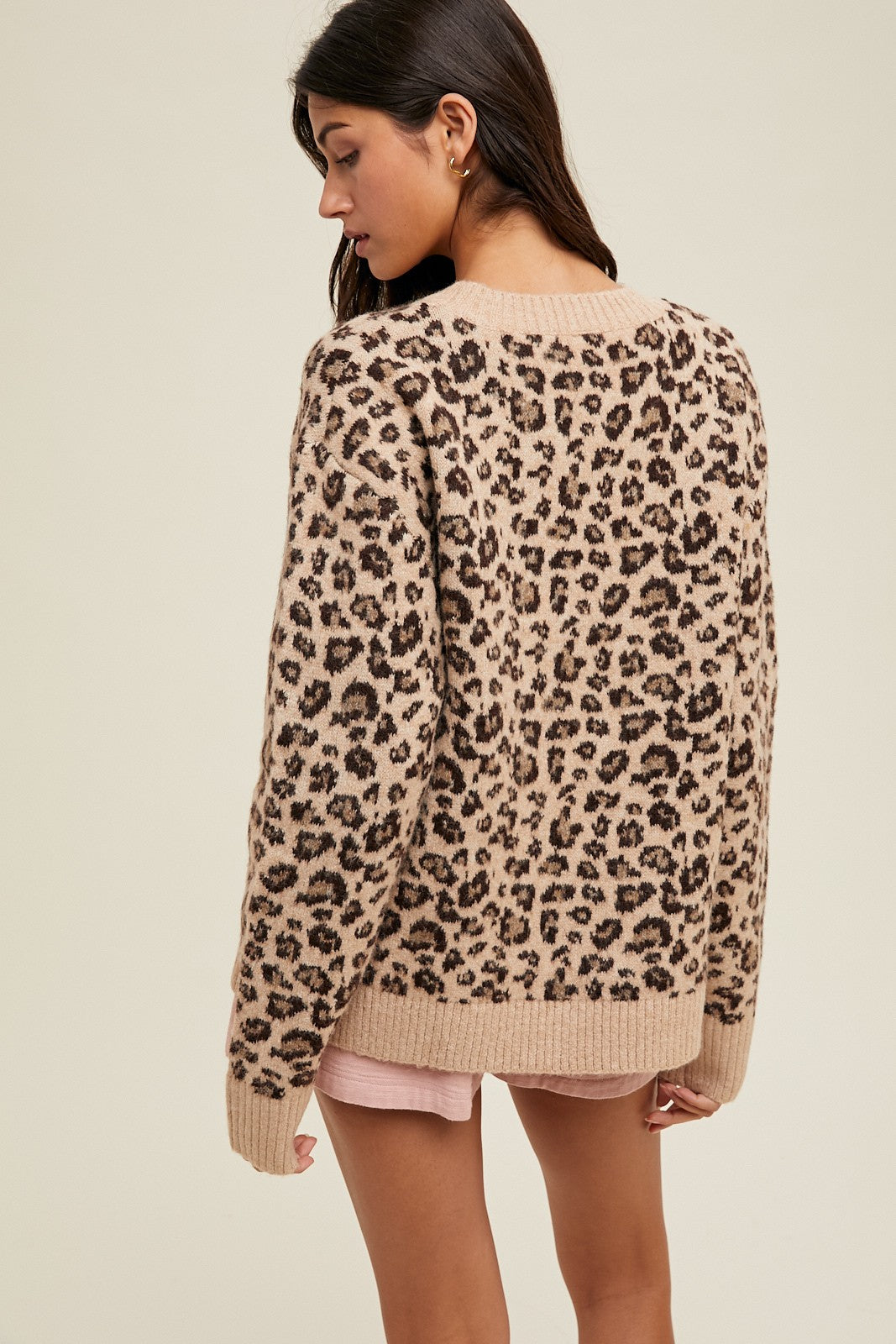 woman wearing a tan leopard print sweater with a relaxed fit and long sleeves, shown from the back