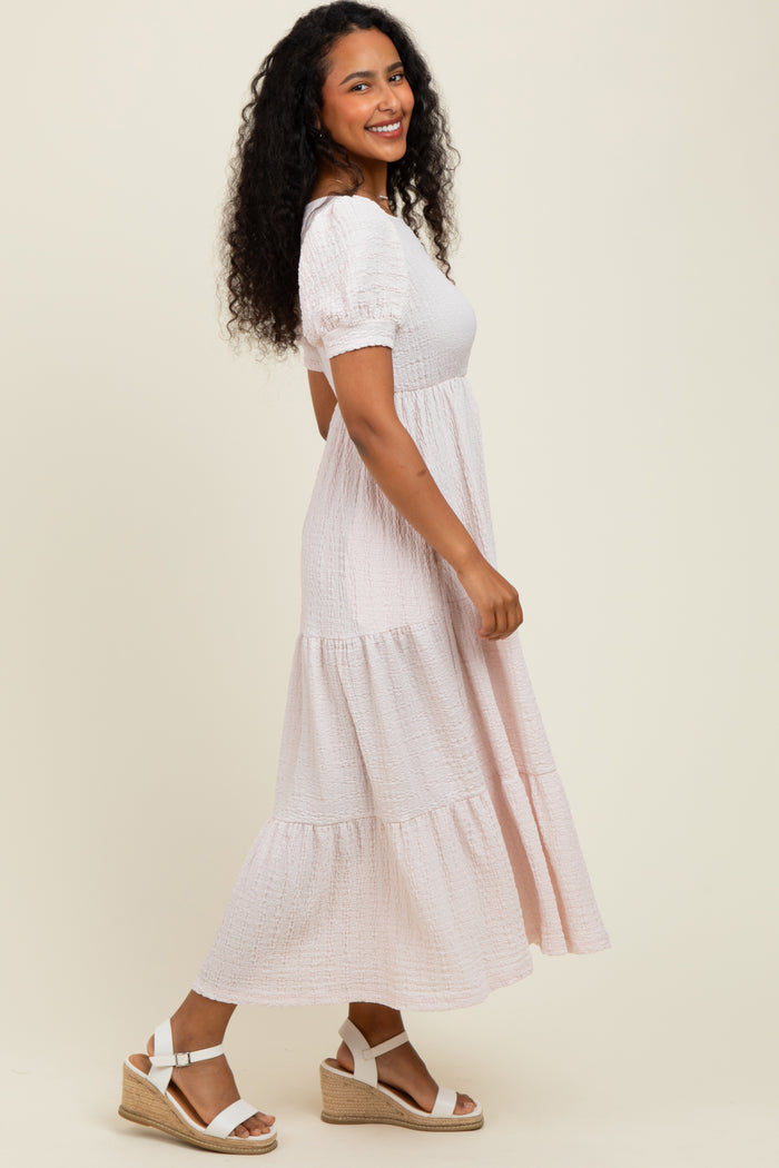 woman wearing a blush pink tiered maxi dress with puff sleeves and white espadrille wedges