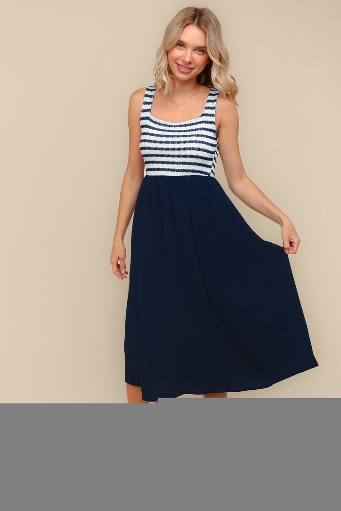 woman wearing a navy blue and white striped maxi dress with a fitted bodice and flowy skirt