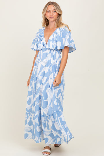 woman wearing a light blue maxi dress with a graphic print and ruffled sleeves
