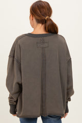 woman wearing an oversized charcoal gray fleece sweatshirt with a back seam detail