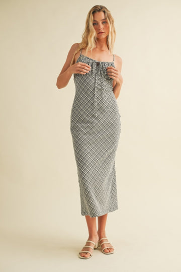 woman wearing a black and white patterned spaghetti strap midi dress with smocked detailing