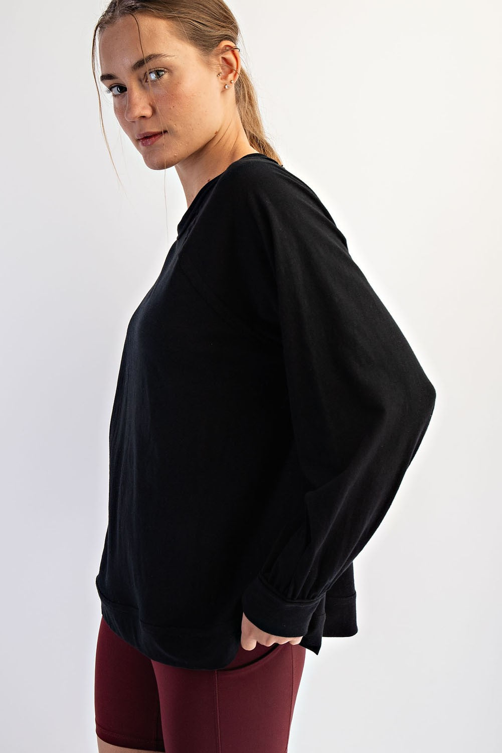 woman wearing a black oversized sweatshirt paired with maroon athletic leggings