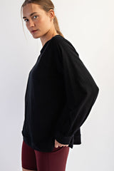woman wearing a black oversized sweatshirt paired with maroon athletic leggings