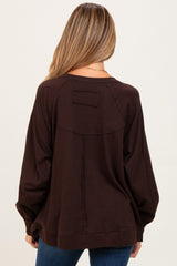 woman wearing a brown oversized maternity sweatshirt with a relaxed fit and puffed sleeves, seen from the back