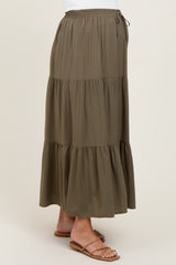 woman wearing a green tiered maternity maxi skirt with an elastic waistband and drawstring detail