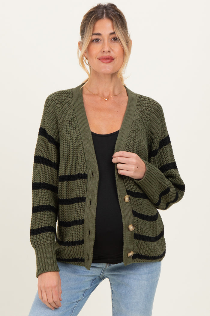 woman wearing a green and black striped maternity cardigan with buttons, showing her baby bump