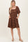 woman wearing a brown floral print short sleeve dress with a square neckline and pockets