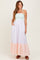 woman wearing a striped maxi dress with a smocked bodice and tiered skirt in pastel colors