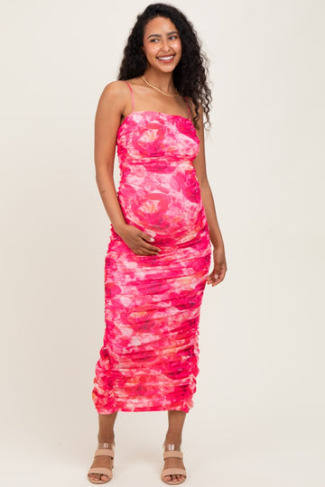 woman wearing a pink tie-dye maternity dress with ruching and a visible baby bump