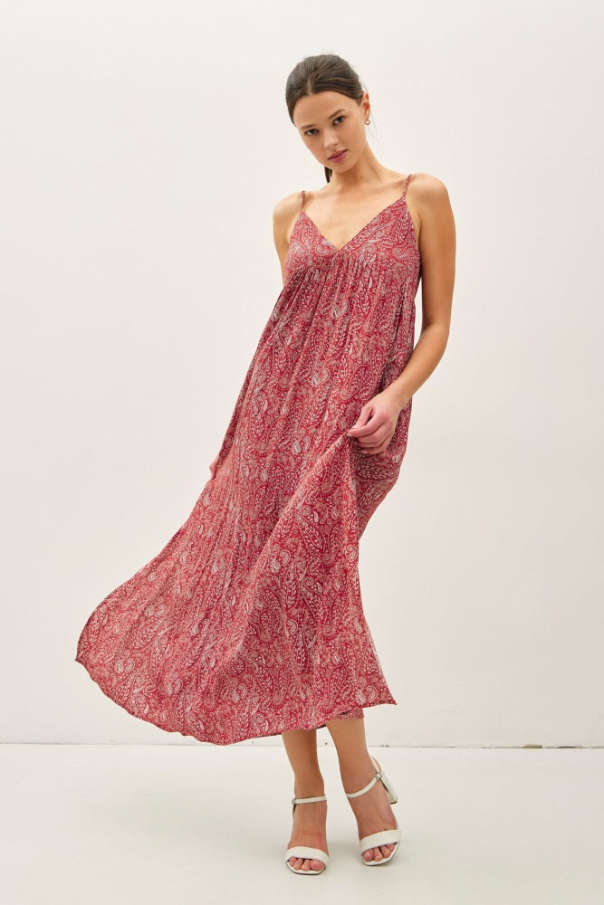 woman wearing a red patterned maxi dress with spaghetti straps and flowing skirt