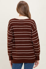 woman wearing a brown and white striped maternity sweater, showing the back view with a loose fit and ribbed cuffs