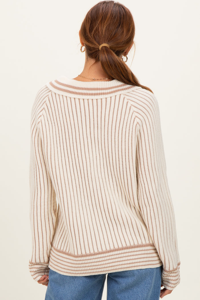 woman wearing a cream and beige striped sweater with a relaxed fit, showing the back and side view