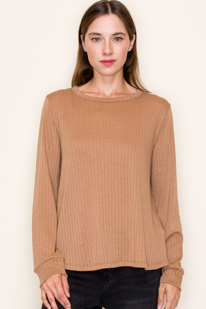 woman wearing a ribbed long sleeve shirt in a warm brown color with a round neckline