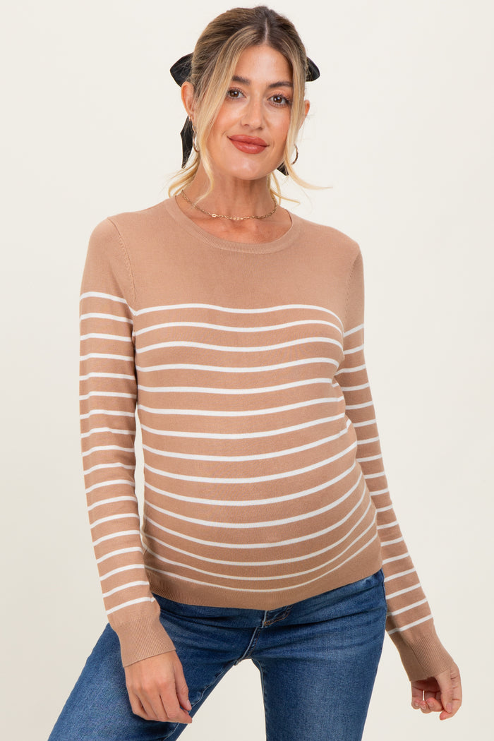 woman wearing a tan striped maternity sweater with a round neckline and long sleeves, showcasing her baby bump
