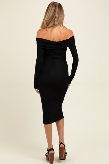 woman wearing a black off-shoulder maternity dress with long sleeves and a fitted silhouette