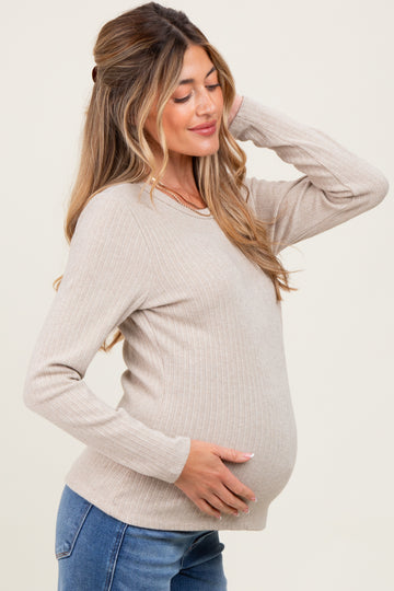 woman wearing a beige ribbed maternity sweater and showcasing her baby bump