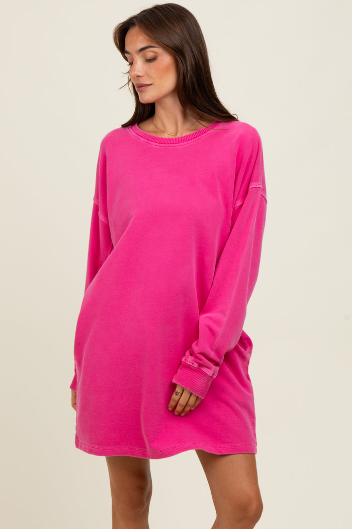 woman wearing a vibrant pink oversized sweatshirt dress with long sleeves and a relaxed fit