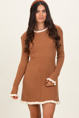 woman wearing a brown ribbed sweater dress with cream ruffle trim details on the neckline and sleeves