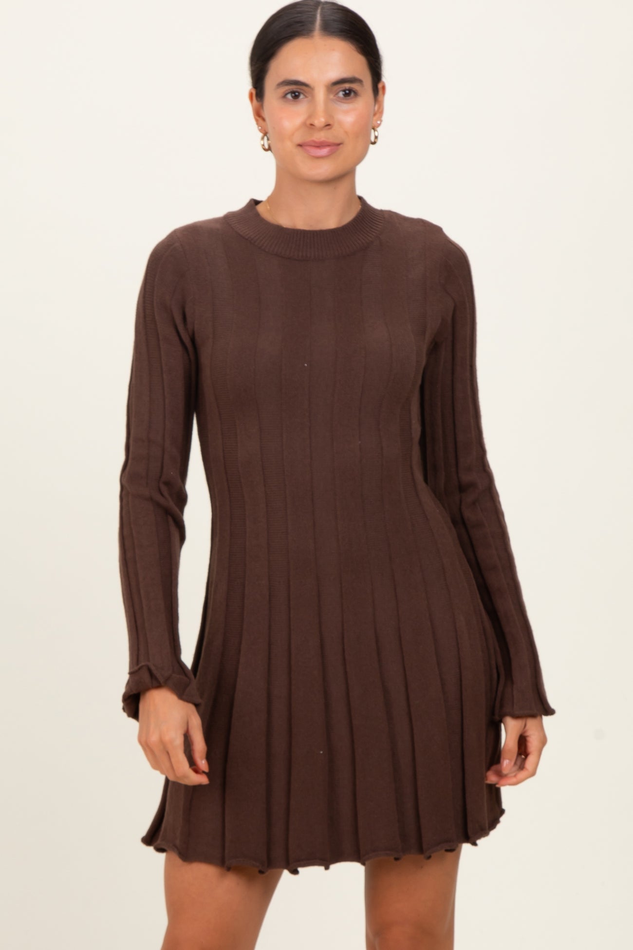 woman wearing a chocolate brown ribbed knit long sleeve dress with a flared skirt and fitted bodice