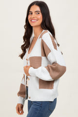 woman wearing a white and beige checkerboard patterned cardigan with button closure and fitted sleeves
