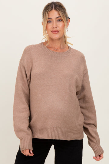 woman wearing a beige oversized maternity sweater with a relaxed fit and long sleeves, baby bump visible