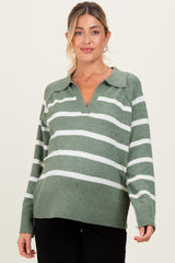 woman wearing a green striped maternity sweater with a v-neck and long sleeves, highlighting her baby bump