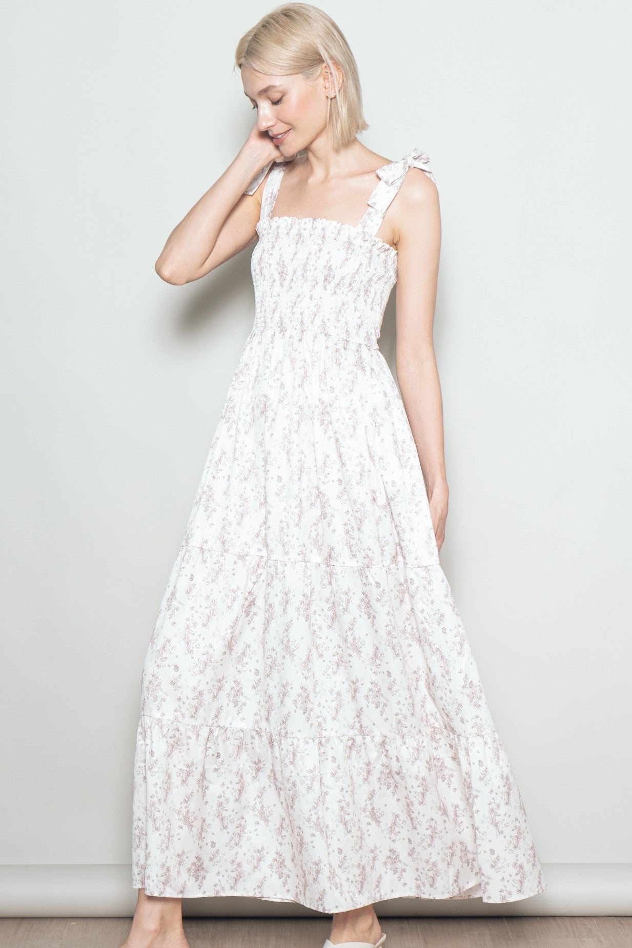 woman wearing a white floral maxi dress with ruffled straps and a smocked bodice