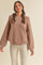 woman wearing a blush oversized ribbed sweater with balloon sleeves paired with white corduroy pants