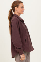 woman wearing a burgundy oversized button-up shirt jacket with a relaxed fit and side pockets