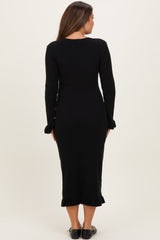 woman wearing a black ribbed maternity dress with long sleeves and ruffled hem, seen from the back