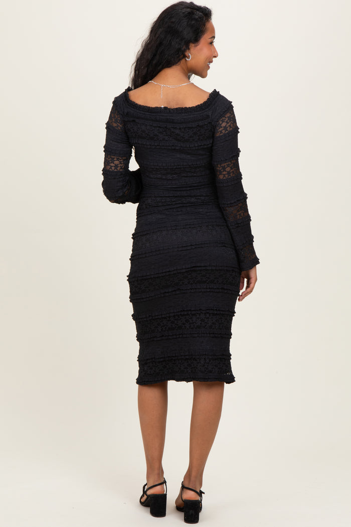 woman wearing a black lace maternity dress with long sleeves and a fitted silhouette, showing her baby bump from the back