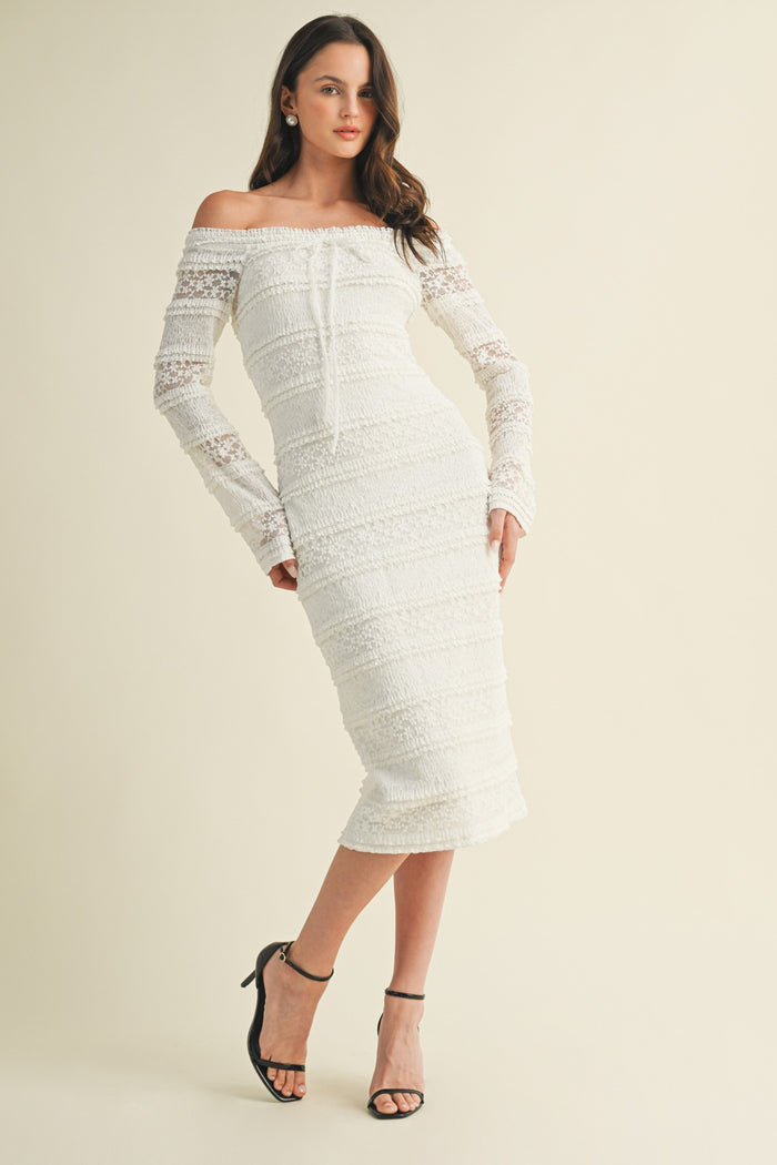 woman wearing a white off-the-shoulder midi dress with lace long sleeves and a fitted silhouette