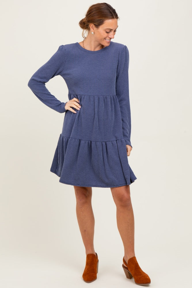 woman wearing a navy blue striped long sleeve tiered dress with a flared skirt and brown ankle boots