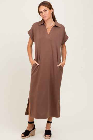 woman wearing a brown short sleeve maxi dress with a collar and side pockets, standing in wedge sandals