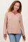 woman wearing a beige oversized waffle knit sweater with a maroon collar and side slits, paired with blue jeans